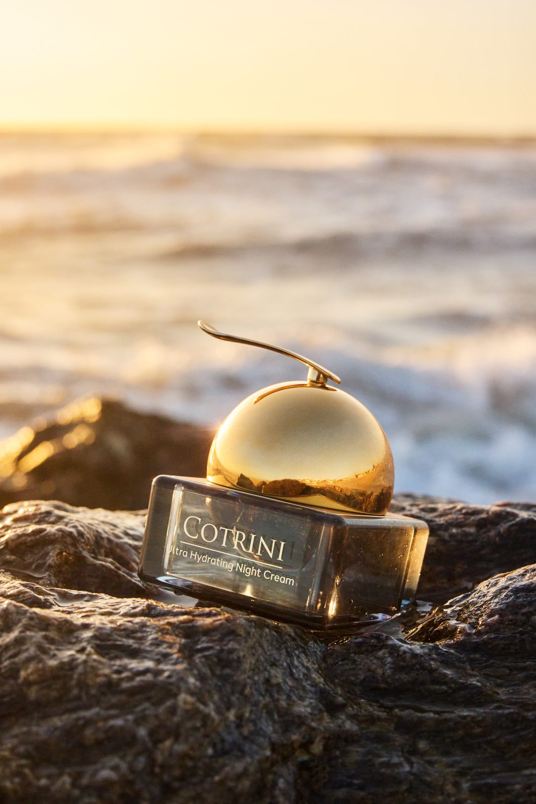 Cotrini Night Cream on ocean rocks at sunset in Porto