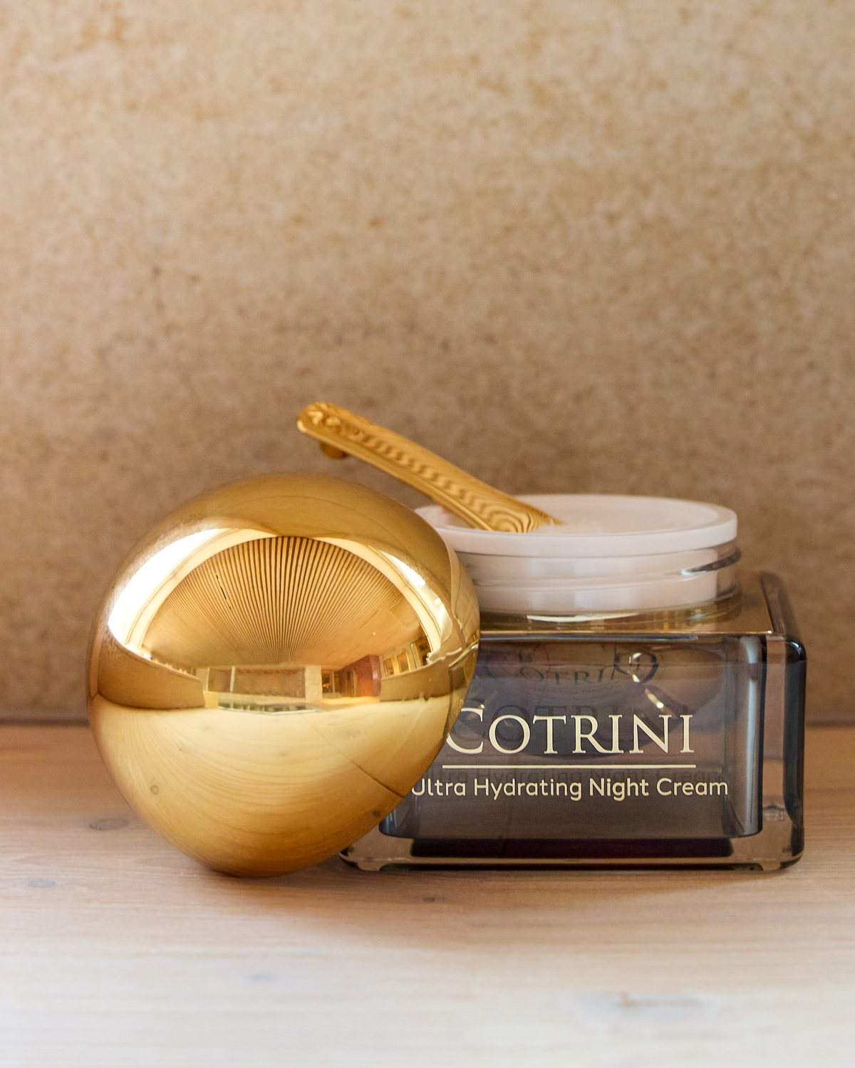 Night Cream open beside its gold dome lid and spatula