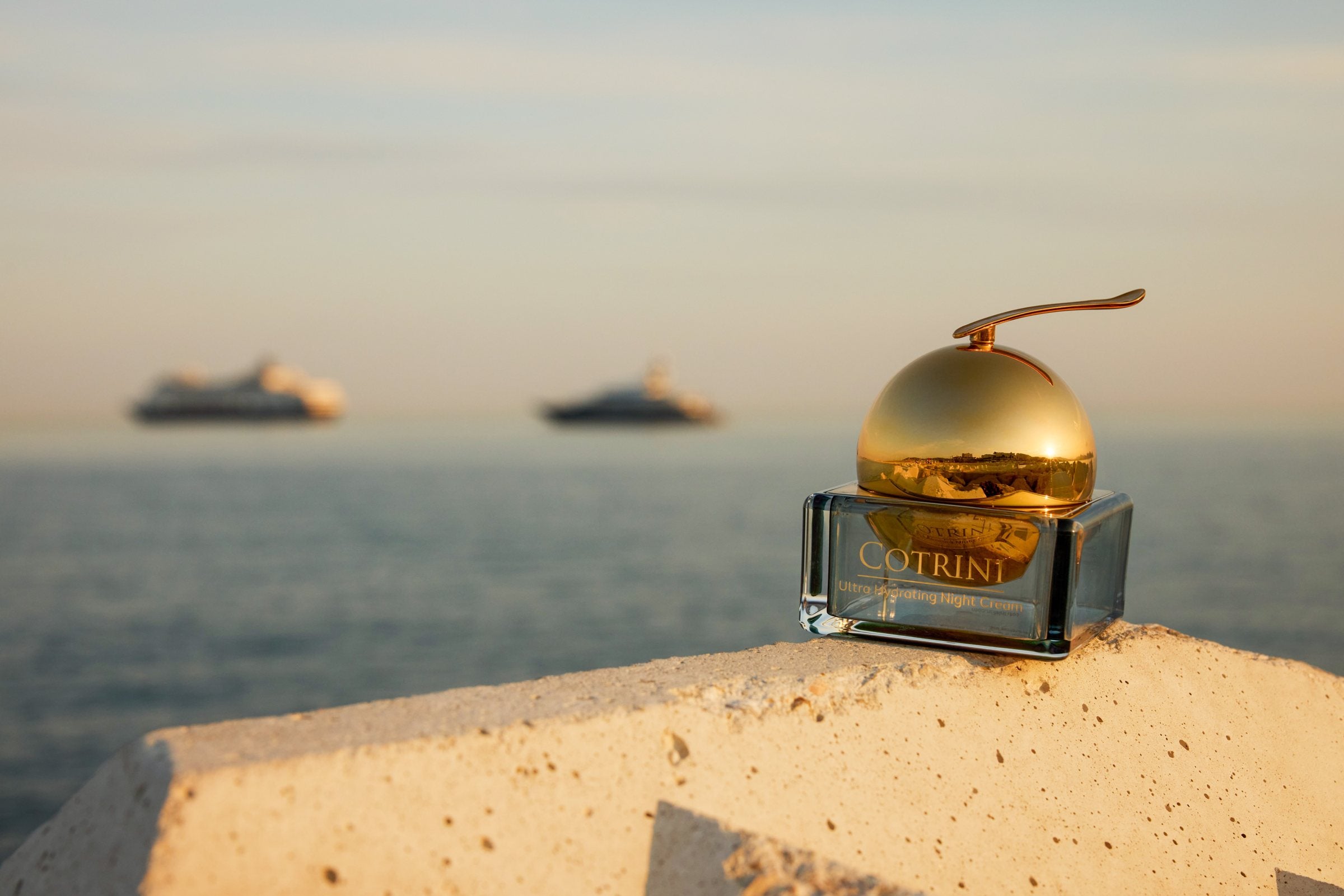 Cotrini Ultra Hydrating Night Cream on a sunlit stone ledge above the sea in Cannes