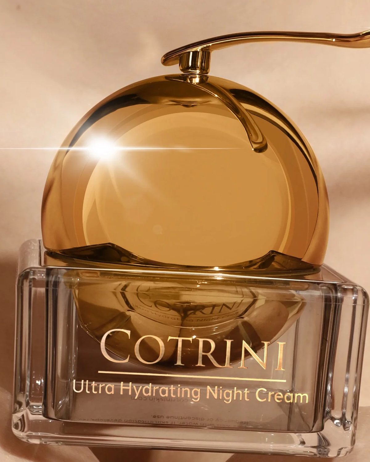 The Night Cream jar with its gold dome lid on cream silk